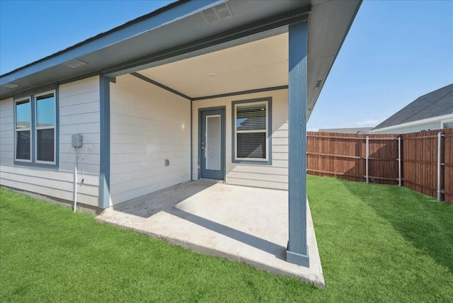 rear view of property featuring a patio, fence, and a yard
