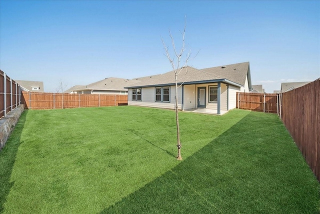 rear view of property with a lawn, a fenced backyard, and roof with shingles