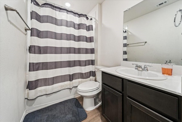bathroom featuring visible vents, wood finished floors, shower / tub combo, vanity, and toilet