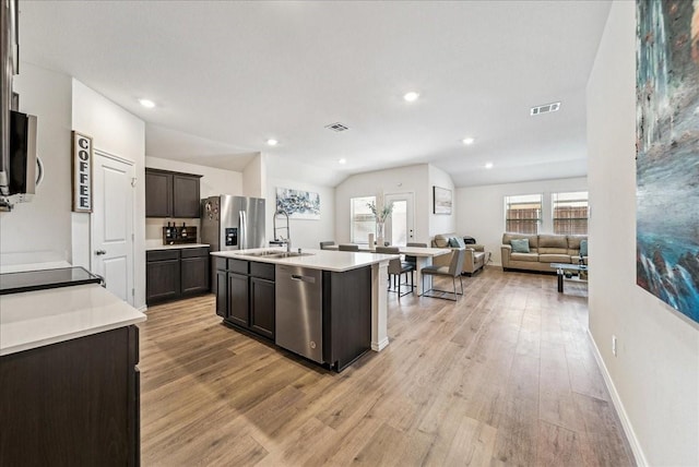 kitchen with a sink, appliances with stainless steel finishes, light wood-style flooring, and visible vents