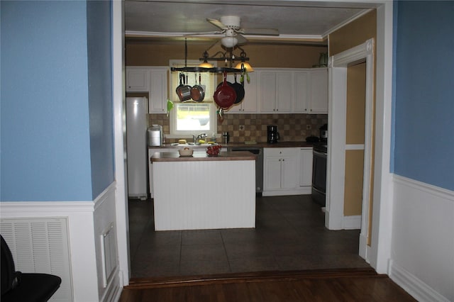 kitchen with stainless steel fridge, electric range oven, backsplash, black dishwasher, and white cabinets