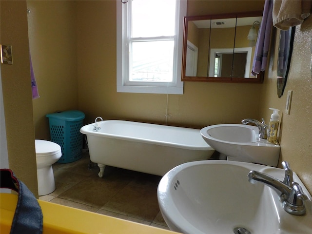 bathroom with tile patterned flooring, sink, a bath, and toilet