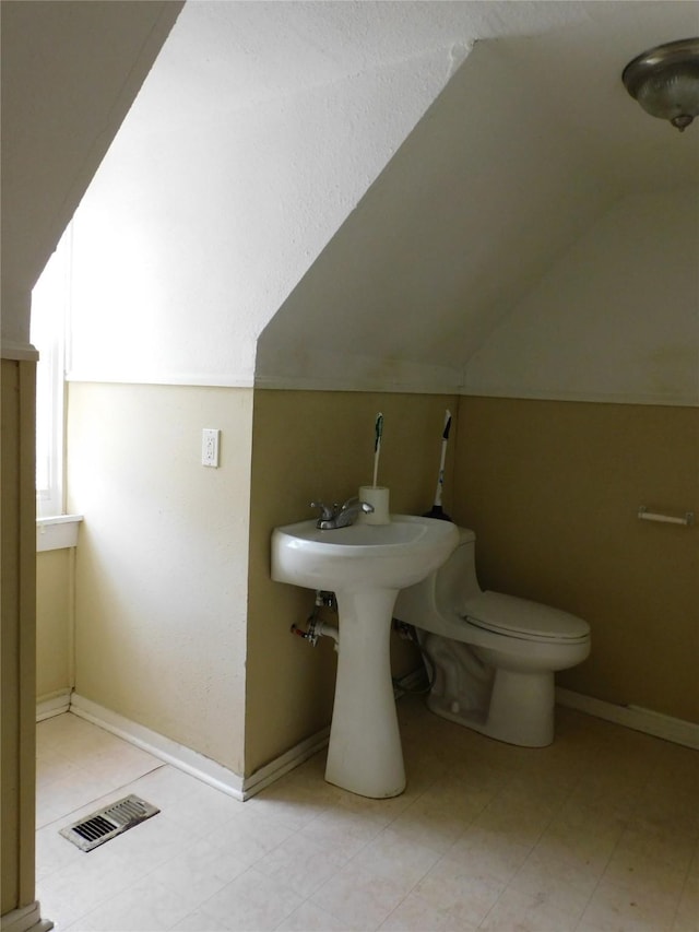 bathroom featuring vaulted ceiling and toilet