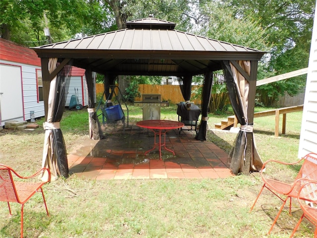 view of patio with a gazebo, grilling area, and a storage unit