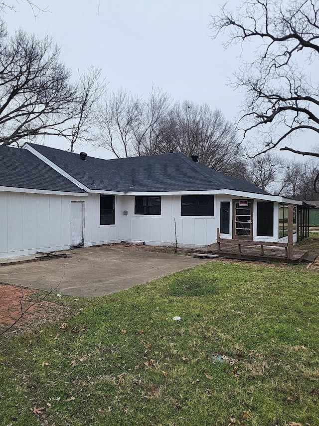 back of property with a lawn and a patio