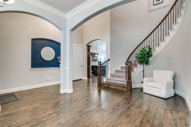 foyer featuring ornamental molding, stairway, dark wood finished floors, and baseboards