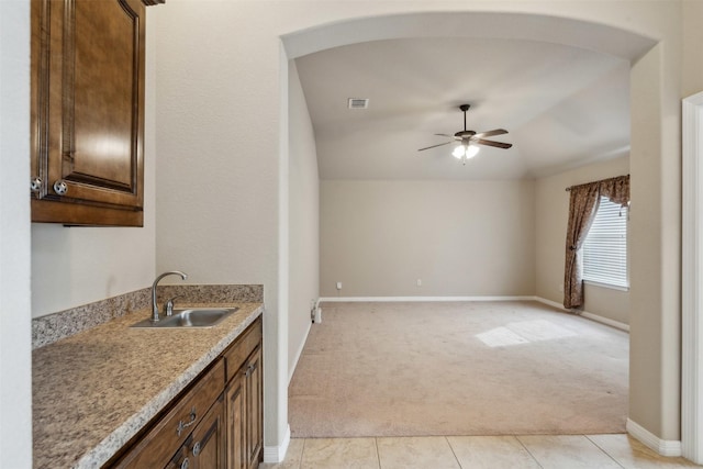 kitchen with light carpet, sink, vaulted ceiling, and ceiling fan