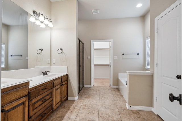 bathroom featuring vanity, tile patterned floors, independent shower and bath, and a healthy amount of sunlight