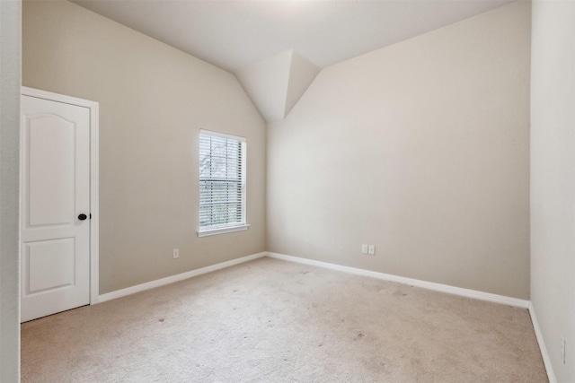 empty room with lofted ceiling and light carpet