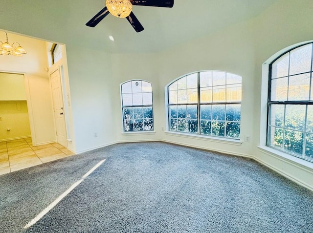 empty room featuring carpet flooring and ceiling fan with notable chandelier