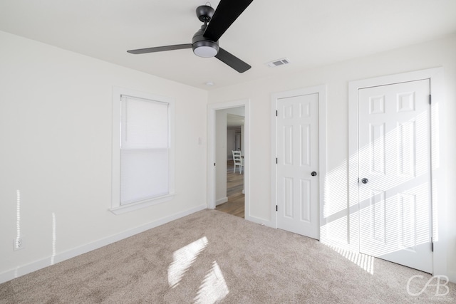 unfurnished bedroom featuring light carpet and ceiling fan