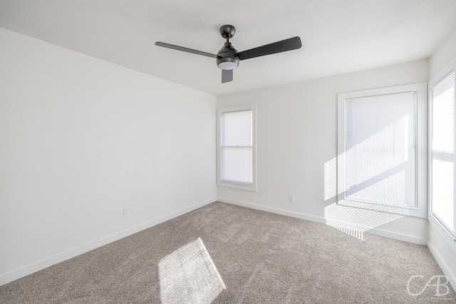 carpeted empty room with plenty of natural light and ceiling fan