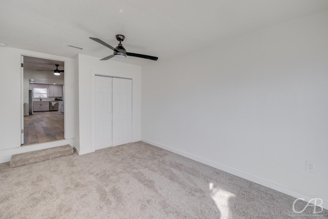 unfurnished bedroom with ceiling fan, carpet floors, and a closet