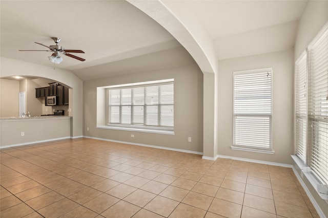 unfurnished living room featuring light tile patterned flooring, vaulted ceiling, and ceiling fan