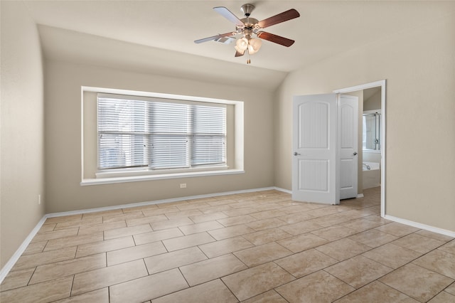 tiled spare room featuring vaulted ceiling and ceiling fan