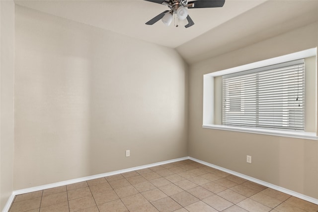 empty room with vaulted ceiling, ceiling fan, and light tile patterned flooring