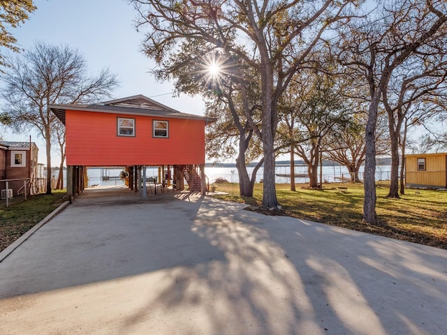 view of front of house with a carport and a water view