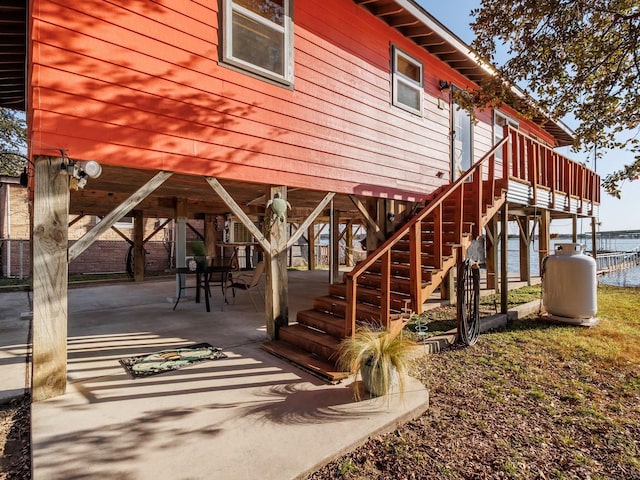 exterior space featuring a deck with water view and a patio area