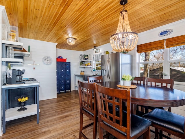 dining area featuring a notable chandelier, wood-type flooring, wooden ceiling, and sink