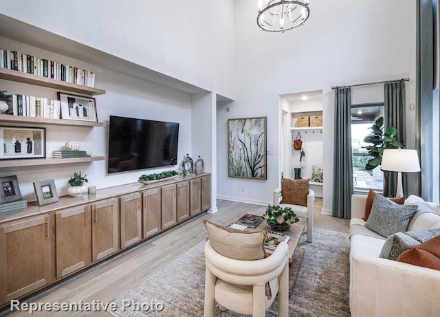 1250 Falls Rush Way, Royse City, TX 75189 - living room featuring an inviting chandelier, a towering ceiling, and light hardwood / wood-style flooring