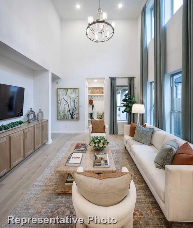 1250 Falls Rush Way, Royse City, TX 75189 - living room with an inviting chandelier, a towering ceiling, plenty of natural light, and wood-type flooring