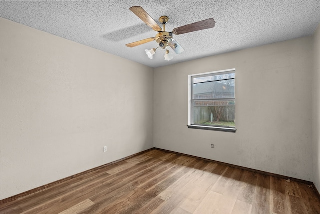 spare room with wood-type flooring, ceiling fan, and a textured ceiling