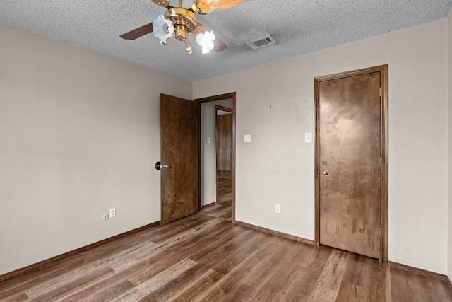 unfurnished bedroom featuring ceiling fan, hardwood / wood-style flooring, and a textured ceiling