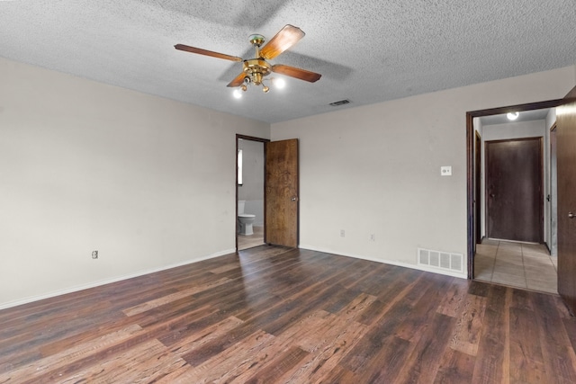 empty room with dark hardwood / wood-style flooring, a textured ceiling, and ceiling fan