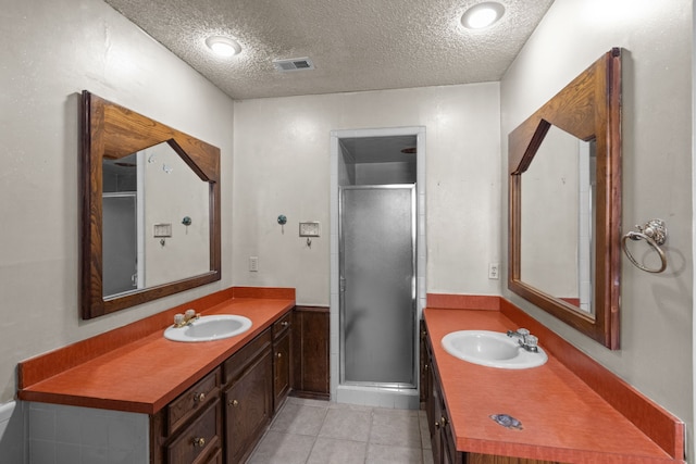 bathroom featuring tile patterned floors, an enclosed shower, vanity, and a textured ceiling