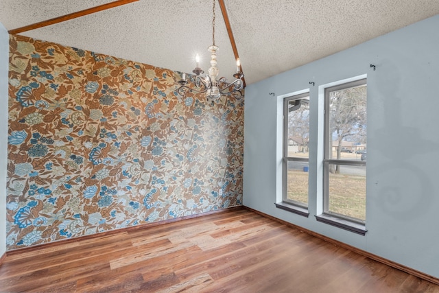 unfurnished dining area with wood-type flooring, a notable chandelier, and a textured ceiling