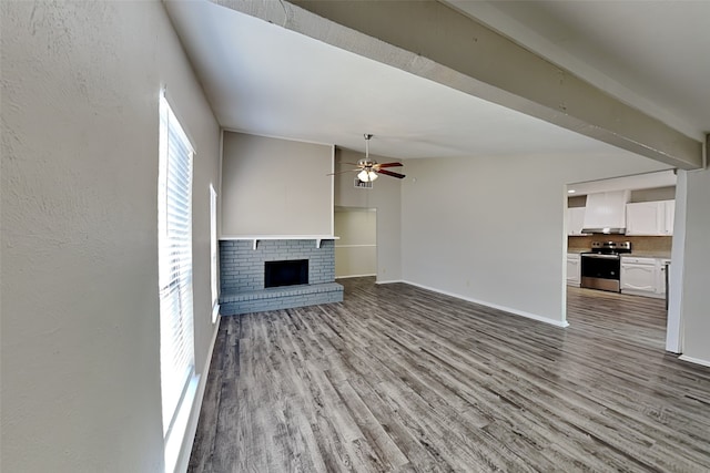 unfurnished living room featuring lofted ceiling with beams, ceiling fan, light hardwood / wood-style floors, and a brick fireplace