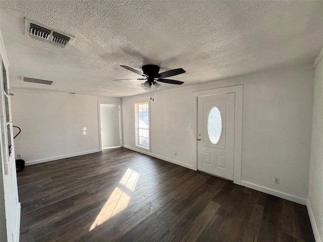 foyer entrance with ceiling fan, visible vents, and dark wood finished floors