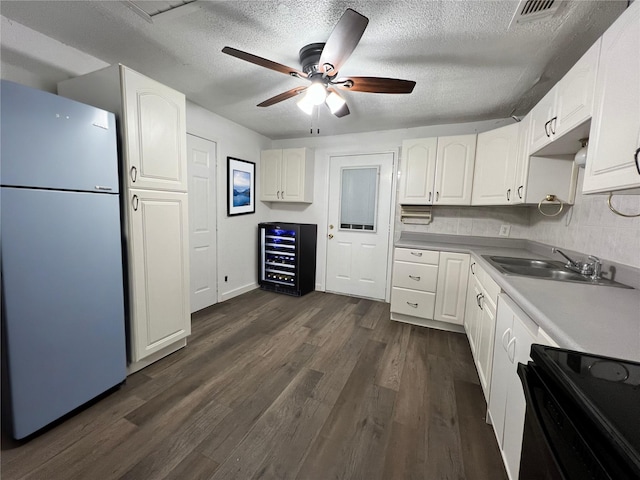 304 Lockwood St, White Settlement, TX 76108 - kitchen featuring freestanding refrigerator, electric stove, a sink, beverage cooler, and white cabinetry