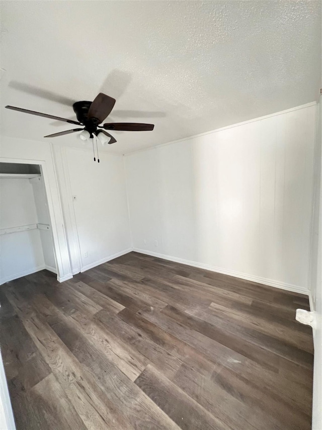 unfurnished bedroom with a closet, dark wood-style flooring, a textured ceiling, and a ceiling fan
