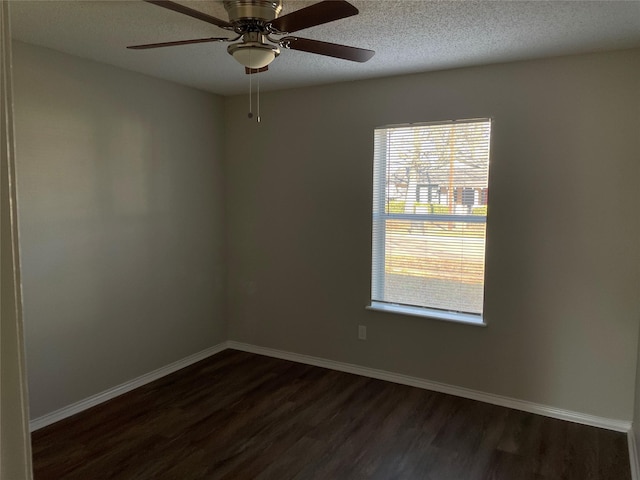 empty room featuring ceiling fan, dark hardwood / wood-style floors, and a textured ceiling