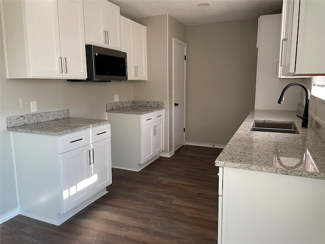 kitchen with sink, white cabinets, and dark hardwood / wood-style flooring