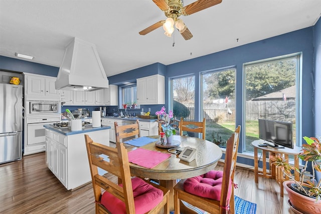 dining space featuring wood-type flooring and ceiling fan