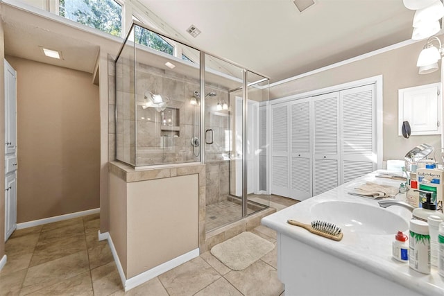 bathroom with tile patterned flooring, vanity, and walk in shower