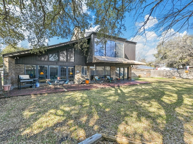 back of property with a patio area and a lawn