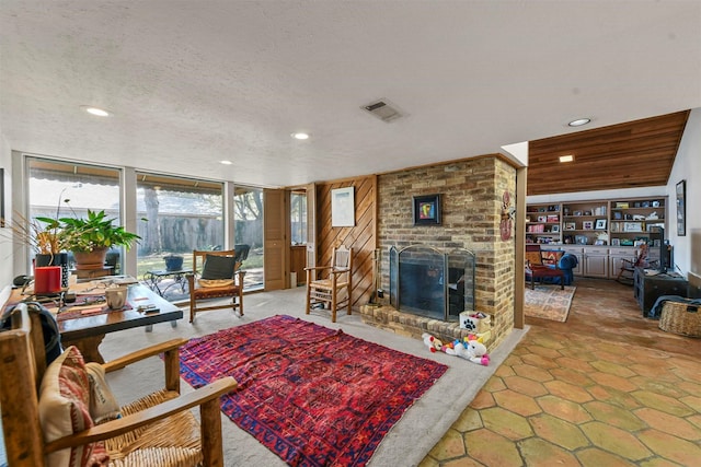 living room featuring a brick fireplace and a textured ceiling