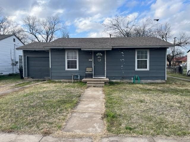 single story home with a garage and a front lawn