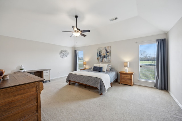 carpeted bedroom featuring multiple windows, vaulted ceiling, and ceiling fan