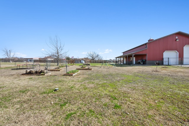 view of yard with a garage and an outbuilding