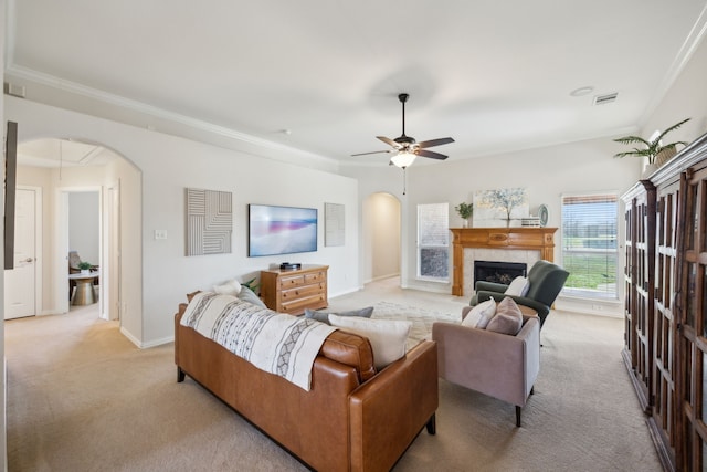 carpeted living room with crown molding, a fireplace, and ceiling fan