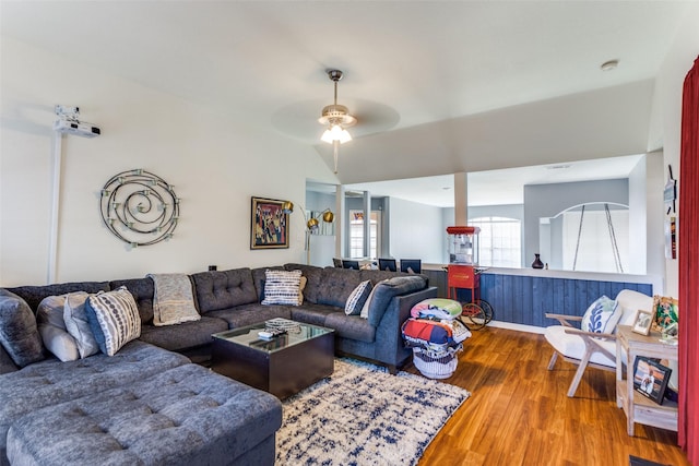 living room featuring ceiling fan, wood-type flooring, and vaulted ceiling