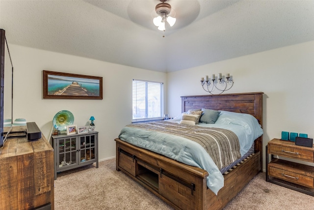 bedroom featuring ceiling fan, vaulted ceiling, light carpet, and a textured ceiling