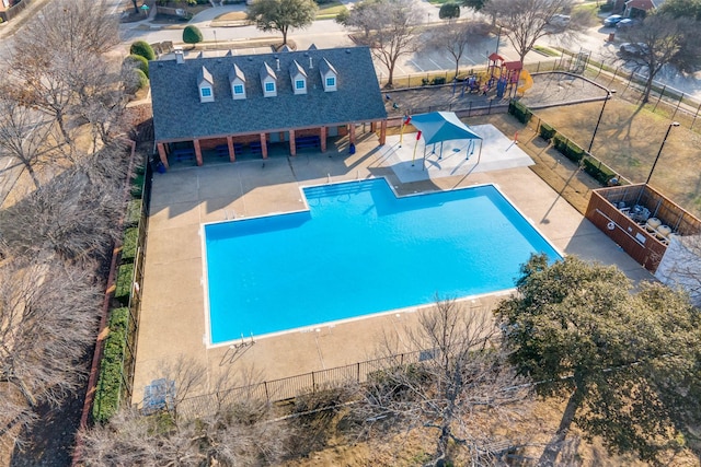 view of swimming pool with a playground and a patio area