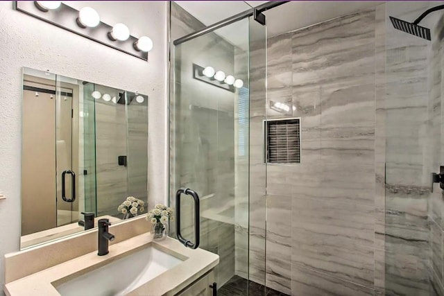 bathroom featuring vanity and a shower with shower door