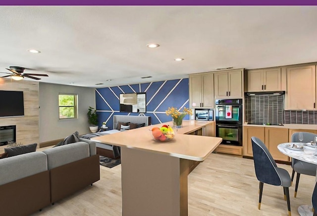 kitchen featuring a kitchen island, a fireplace, double oven, backsplash, and light hardwood / wood-style floors