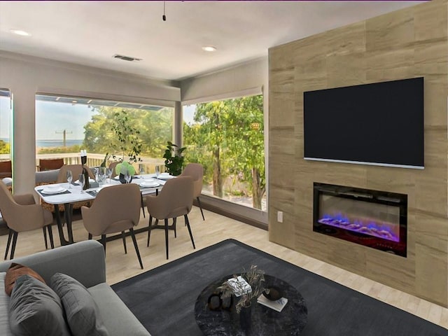 living room with a tiled fireplace and light hardwood / wood-style floors